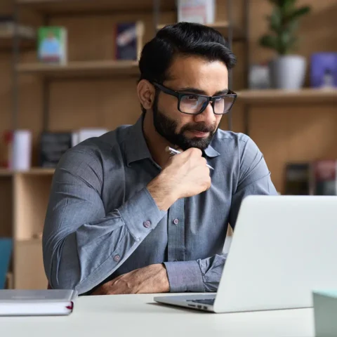 A man sat at a desk with a laptop